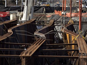 Crews work to repair several steel girders that twisted during installation of a bridge over Groat Road in March.