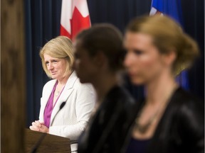 Press secretary Cheryl Oates listens to Premier Rachel Notley.