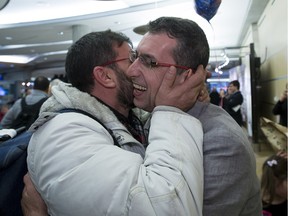 Taher Istabouly, right, hugs his brother Maher Istanbouli as Maher and his family arrive at the Edmonton International Airport on Dec. 8, 2015, after leaving Syria via Turkey.