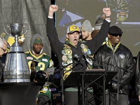 Edmonton Mayor Don Iveson raises his arms in celebration beside the Grey Cup in front of thousands of fans during a celebration rally at Churchill Square in downtown Edmonton on December 1, 2015. The Edmonton Eskimos won the CFL Grey Cup Championship by defeating the Ottawa Redblacks.