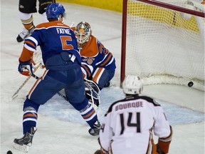 Edmonton Oilers defenceman Mark Fayne watches the puck go past goalie Viktor Fasth as does Anaheim Ducks forward Rene Bourque during NHL action on Dec. 12, 2014 in Edmonton.
