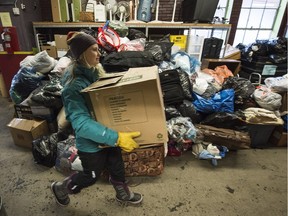 Volunteer Corrine McKell helps unload a truck of donations for Syrian refugee families at the Edmonton Emergency Relief Services in Edmonton on Wednesday Dec. 16, 2015.