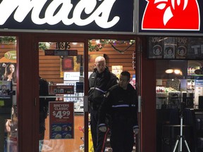Homicide detectives investigate at a Mac's convenience store in Edmonton on Dec. 18.  Two men were killed early Friday when they were shot during two convenience store holdups.