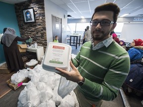 Volunteer Yasin Cetin shows one of 300 Christmas meals prepared Friday at the Rahma Mosque in Edmonton.