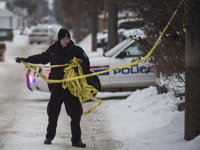 Police remove crime scene tape after investigating the scene of a possible homicide in the alley at 81 Street in Edmonton on Monday Dec. 28.