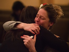 Sara Chaloux gets a hug during the viewing for her friend Ricky Cenabre, 41, at Serenity Funeral Service in Edmonton Dec. 29, 2015. Cenabre was shot and killed Dec. 18 as he worked a night shift at a Pleasantview Mac's store.