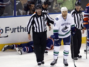 Vancouver Canucks' Zack Kassian heads to the penalty box after breaking former Edmonton Oilers forward Sam Gagner's jaw with his stick during an NHL exhibition game on Sept. 21, 2013 at Rexall Place.  Kassian plays his first game in an Oilers uniform on Thursday.