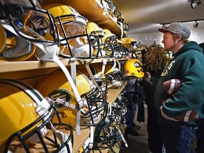 Kyle Leblanc, from Lloydminster, looks at helmets during the Edmonton Eskimos annual locker-room sale at Commonwealth Stadium in Edmonton on Dec. 12, 2015.