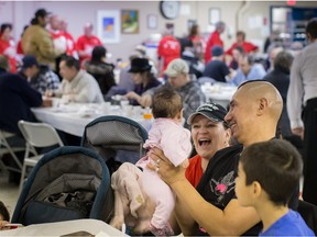 Willard Courtoreille proudly shows his daughter Willow to volunteer Wendy Walsh during the Salvation Army's annual Community Christmas Dinner in Edmonton on Dec. 2, 2014. The Salvation Army is one of many charities in need of donations this Christmas season.