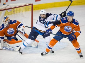 Edmonton Oilers' Mark Fayne (5) and Winnipeg Jets' Mathieu Perreault (85) fight in front of Oilers goalie Cam Talbot (33) during a Dec. 21, 2015, game at Rexall Place. The Oilers won 3-1.