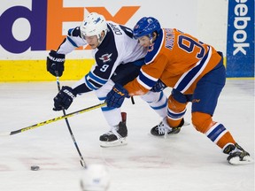 Edmonton Oilers' Ryan Nugent-Hopkins (93) and Winnipeg Jets' Andrew Copp (9) fight for the puck during NHL action at Rexall Place in Edmonton on December 21, 2015.