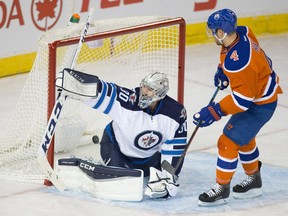 The Oilers' Teddy Purcell (not pictured) scores on the Winnipeg Jets goalie Connor Hellebuyck (30) for the second time with an assist from Taylor Hall (4) at Rexall Place on Dec. 21, 2015.