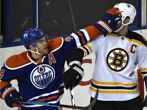 Edmonton Oilers' Taylor Hall (4) sticks his glove into Boston Bruins' Zdeno Chara (33) face during a game at Rexall Place on Dec. 3, 2015.