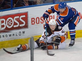 Josh Manson (42) and Taylor Hall (4) battle as the Edmonton Oilers take on the Anaheim Ducks at Rexall Place in Edmonton, Dec. 31, 2015.