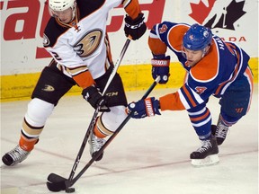 Josh Manson (42) and Taylor Hall (4) battle as the Edmonton Oilers play the Anaheim Ducks at Rexall Place in Edmonton, Dec. 31, 2015.
