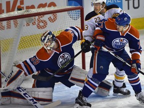 Edmonton Oilers goalie Anders Nilsson makes a save with defenceman Oscar Klefbom and Buffalo Sabres' Sam Reinhart around the net during an NHL game at Rexall Place on Dec. 6, 2015.