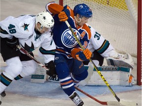 Centre Ryan Nugent-Hopkins (93) gets a shot on goaltender Martin Jones (31) with centre Tomas Hertl (48) checking him as the Edmonton Oilers play the San Jose Sharks at Rexall place in Edmonton, Dec. 9, 2015.
