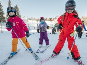 Kaia Hawley, left, and Hayley Bulat give Eden Hawley a pull at Snow Valley Ski Club. A low Canadian dollar and favourable weather have given Western Canadian ski resorts a boost this season.