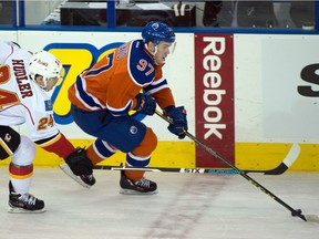 Connor McDavid of the Edmonton Oilers gets past Jiri Hudler of the Calgary Flames during an NHL game at Rexall Place on Oct. 31, 2015.