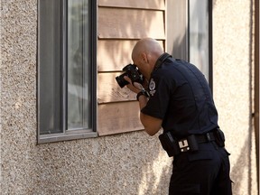 A police investigator takes a photo at the scene of Tye Christopher Kaye's murder.
