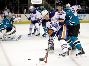 Edmonton Oilers forward Jordan Eberle fights for the puck with San Jose Sharks' Mirco Mueller on Dec. 9, 2014 in San Jose, Calif.