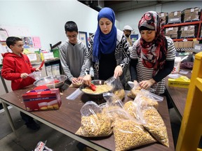 Volunteers from Islamic Family Social Services Association help bag chick peas at the Edmonton Food Bank.