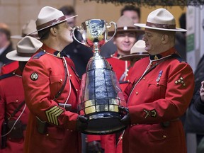 An RCMP officer kisses the Grey Cup as he prepares to walk onto the field at the beginning of the 103rd Grey Cup in Winnipeg between the Edmonton Eskimos and the Ottawa Redblacks on Nov. 29, 2015.