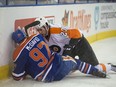 Edmonton Oilers' Connor McDavid sits on the ice with a broken left clavicle after a hit from Brandon Manning of the Philadelphia Flyers at Rexall Place in Edmonton on Nov. 3, 2015.