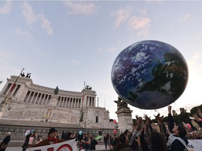 People in Rome play with a giant balloon representing Earth at a climate change on November 29, 2015