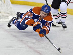 Edmonton Oilers' Nikita Nikitin (86) dives for the puck against the Chicago Blackhawks during first period NHL hockey action in Edmonton on Jan. 9, 2015.