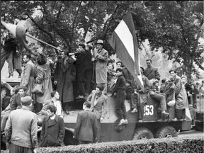 Residents of Budapest waving Hungarian flags demonstrate on Nov. 12, 1956 atop a Soviet army tank against the intervention of Soviet troops.