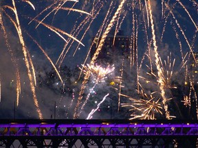 An unidentified person runs across the top of the High Level Bridge as the Canada Day Fireworks explode above in Edmonton on July 1, 2015.