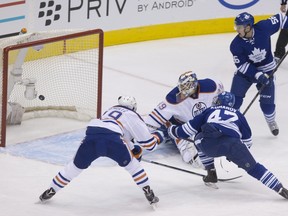 Toronto Maple Leafs' Leo Komarov (47) scores on Edmonton Oilers goaltender Anders Nilsson as defenceman Justin Schultz (19) defends during first-period NHL action in Toronto on Monday, Nov. 30, 2015.