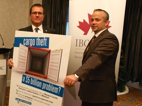 Bill Adams, left, western and Pacific vice-president of the Insurance Bureau of Canada, and Dan Duckering, chairman of the Alberta Motor Transport Association, help launch a cargo theft reporting program in Edmonton on Tuesday.
