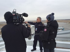 Edmonton International Airport Fire Chief Burl Hamm is interviewed by a crew filming a reality TV show at the airport.