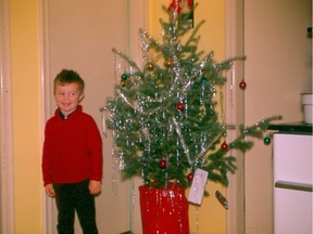 Ann Hender's oldest child, Stephen, poses with their tiny tree in the Twylite Motel in Vegreville at Christmas 1966.