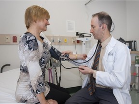 Breast cancer clinical trial participant Debbie Cameron (left) has her blood pressure taken by University of Alberta cardiologist Dr. Ian Paterson at the Peter S. Allen MR Research Centre at the U of A Hospital on Nov. 4.