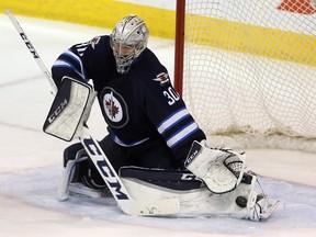 Winnipeg Jets goaltender Connor Hellebuyck (30) makes a pad save against the New York Rangers during third period NHL hockey action in Winnipeg, Friday, December 18, 2015.
