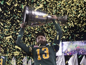 Edmonton Eskimos QB  Mike Reilly hoists the Grey Cup after defeating the Ottawa Redblacks in the CFL's championship game in Winnipeg on Nov. 29, 2015.
