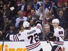 Chicago Blackhawks right wing Patrick Kane (88) celebrates his hat trick against the Toronto Maple Leafs with teammate Artemi Panarin (72) during third period NHL hockey action in Toronto on Friday, January 15, 2016. THE CANADIAN PRESS/Nathan Denette