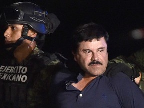 Drug kingpin Joaquin "El Chapo" Guzman is escorted into a helicopter at Mexico City's airport on Jan. 8, 2016, following his recapture during an intense military operation in Los Mochis, in Sinaloa State. Mexican marines recaptured fugitive drug kingpin Joaquin "El Chapo" Guzman on Friday in the northwest of the country, six months after his spectacular prison break embarrassed authorities.