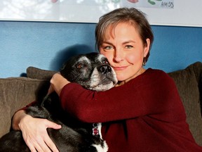 Alison Hughes and her dog Milly sit on the couch together.