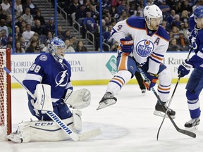 Edmonton Oilers left wing Taylor Hall (4) leaps in the air in an attempt to screen Tampa Bay Lightning goalie Andrei Vasilevskiy (88), of Russia, on a shot during the first period of an NHL hockey game Tuesday, Jan. 19, 2016, in Tampa, Fla. Defending for the Lightning is defenceman Victor Hedman (77).