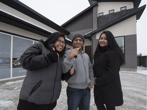 Giovanni Padua, centre, with his wife Edith, left, and daughter Vanessa, picked up the keys to the house his family won in the Caritas Home Lottery in Edmonton on Wednesday Jan. 6.