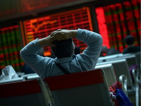 An investor looks at screens showing stock market movements at a securities company in Beijing on Jan. 8, 2016. Chinese equities led another day of volatility across Asia as investors were panicked by Beijing's attempts to stabilize its beleaguered markets, with fears growing the global economy could be teetering.