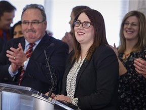 Alberta NDP MLA Deborah Drever, centre, is welcomed back into the NDP caucus by cabinet minister Brian Mason, left, at a news conference in Calgary, Alta., Friday, Jan. 8, 2016.THE CANADIAN PRESS/Jeff McIntosh