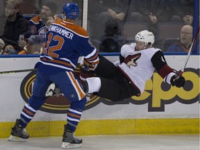 Edmonton Oilers' Rob Klinkhammer flattens Arizona Coyotes' Zbynek Michalek during first period NHL action on Jan. 2, 2015, in Edmonton.