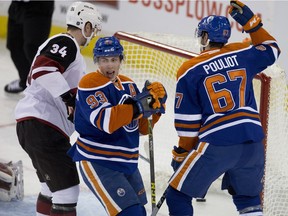 Edmonton Oilers' Ryan Nugen-Hopkins and Benoit Pouliot celebrate a goal scored by Jordan Eberle against the Arizona Coyotes during first period NHL action on Jan. 2, 2015, in Edmonton.