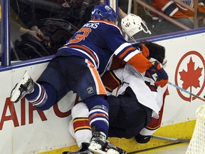 Edmonton Oilers forward Matt Hendricks crunches Florida Panthers defenceman Aaron Ekblad into the boards behind the Florida net during an NHL game at Rexall Place on Jan. 10, 2016.