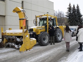 A City of Edmonton snow removal vehicle involved in the death of a pedestrian is examined by a judge and lawyers outside the Edmonton courthouse.